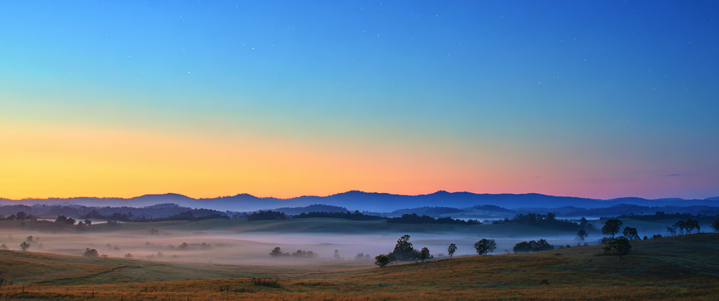 Calm morning sky with soft light breaking over a quiet field, symbolizing the majesty of God’s name in Psalm 8.